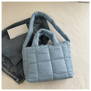 Detailed top view of light blue quilted down tote bag with dual shoulder straps