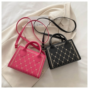 Detail of mini quilted tote bags in pink and black with gold heart embroidery