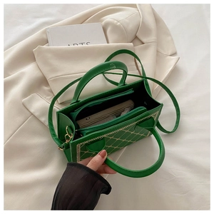 Detail of dark green quilted leather bag featuring gold embroidery and interior zip pocket