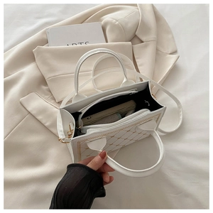 Interior view of white crossbody bag with golden quilting and zipper compartment