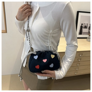 Blue denim drawstring bucket bag featuring colorful heart patches and silver chain strap