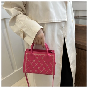 Detail of rose red quilted mini bag with heart embroidery and fine shoulder strap