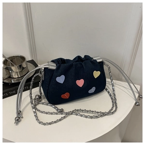 Close-up of blue denim drawstring bucket bag with colorful heart leather patches
