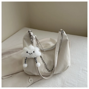 Detail of off-white hobo bag with soft pleated texture and cloud plush charm