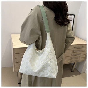Minimalist canvas tote bag with textured weave and light green shoulder straps