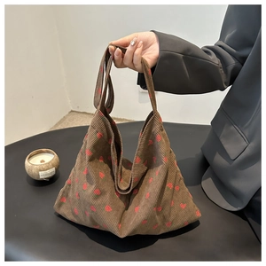 Close-up of brown corduroy tote bag with red strawberry embroidery and long handles