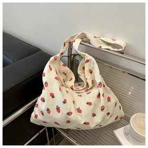 Detail of strawberry printed corduroy tote bag showing its soft texture and large capacity