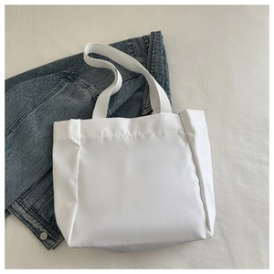Vue détaillée du sac cabas en toile blanc minimaliste avec de larges bandoulières