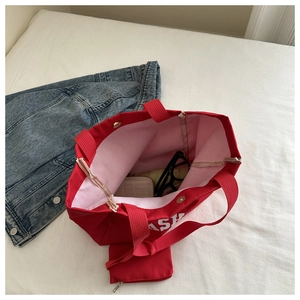 Détail du grand cabas rouge en toile avec fermoir aimanté et une petite pochette assortie