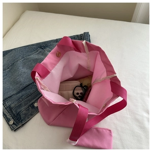 Détail intérieur du sac cabas rose montrant le fermoir magnétique et les accessoires
