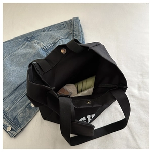 Vue de dessus du grand sac fourre-tout noir avec fermoir magnétique et rangement spacieux