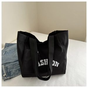 Détail du grand sac cabas en nylon noir avec imprimé FASHION blanc et sangle robuste
