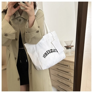 Grand sac cabas blanc en toile avec texte Fashion porté par un mannequin devant un miroir
