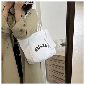 Selfie miroir montrant un sac fourre-tout en toile blanche avec pochette assortie