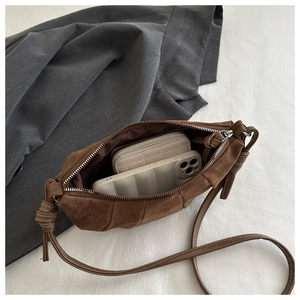 Detail view of brown matte suede crossbody bag showing interior capacity for phone and wallet
