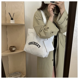 Détail du sac cabas blanc en toile avec imprimé FASHION et pochette assortie en selfie