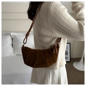 Close-up of vintage dark brown frosted suede shoulder bag with pleated texture design