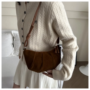 Detailed view of the brown frosted crescent bag with pleated design and knot strap