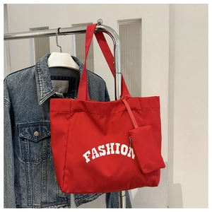 Détail du sac fourre-tout en toile rouge avec lettrage FASHION et pochette assortie