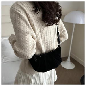 Detail of black pleated shoulder bag with matte finish and knotted leather strap