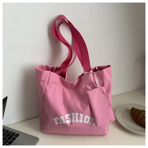 Détail d'un sac cabas en toile rose avec une petite pochette zippée et texte fashion