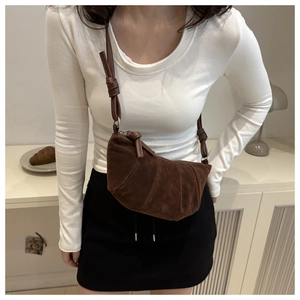 Detailed texture of dark brown suede croissant bag with stitched pleated folds