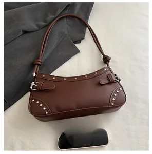 Detail view of brown faux leather hobo bag with silver studs and buckle accents