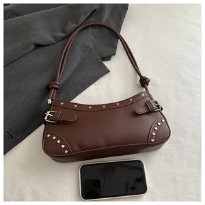 Detail view of dark brown leather underarm bag with silver rivets and metallic buckle