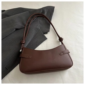 Detailed view of the brown leather shoulder bag featuring a unique knotted strap detail