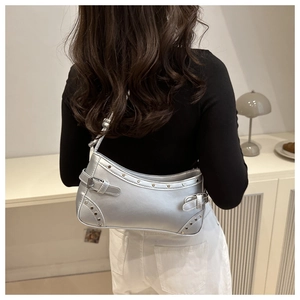 Silver metallic leather shoulder bag with punk rivets and Y2K aesthetic shown on a model