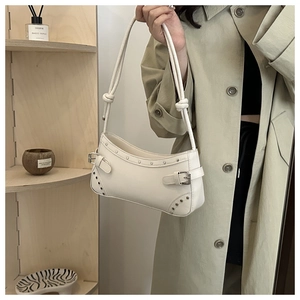 Detail of white vintage underarm bag with silver rivets and sleek knot strap design