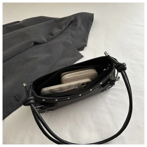 Detail view of black leather underarm bag interior showing storage space and silver rivets