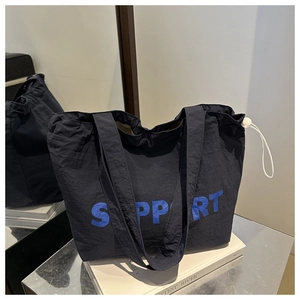 Détail du sac cabas noir avec lettrage Support bleu et fermeture par cordon de serrage