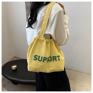Détail du sac fourre-tout jaune avec cordon et texte Support vert sur tissu imperméable