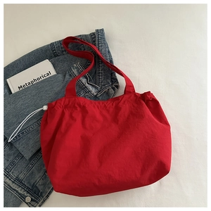 Sac fourre-tout rouge à cordon avec veste en jean bleu et accessoire de livre blanc