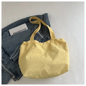 Détail du sac cabas en toile jaune avec cordon de serrage et large bandoulière