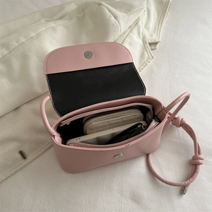 Pink leather shoulder bag with bow detail showing spacious interior and magnetic closure