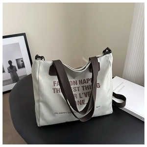 Detail of light gray nylon tote bag with wide brown straps and fashion text print