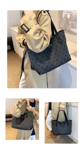 Detail of dark grey tote bag with polka dot pattern and metal bow ornament