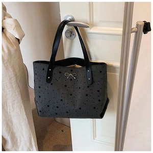 Detailansicht der grauen Canvas-Tasche mit Sternenmuster und silbernem Schleifenanhänger