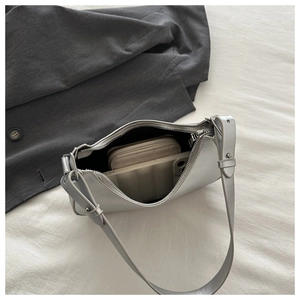 Spacious interior of silver bow shoulder bag showing storage for wallet and smartphone