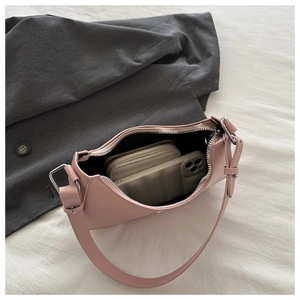 Top view of pink crescent bag showing spacious interior with wallet and phone