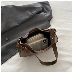 Interior storage view of brown leather crossbody bag with wallet and smartphone