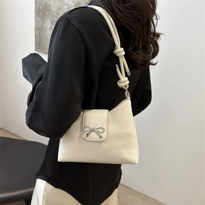 Sac seau minimaliste blanc crème avec un nœud en argent et une bandoulière nouée