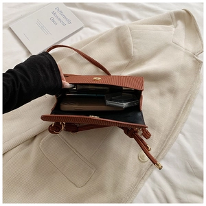 Internal view of brown corduroy crossbody bag showing phone and lipstick storage