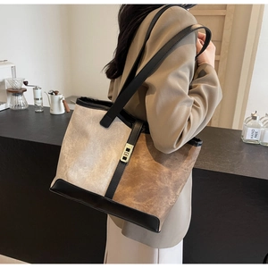 Detail of suede patchwork tote bag with gold metal twist lock and black leather trim