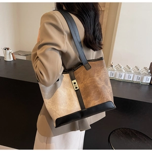 Close-up of a retro contrast color tote bag with metal buckle worn by a model