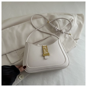 Detailed shot of white PU leather bag with gold geometric buckle on a cream blazer