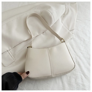 Gros plan du sac seau blanc crème minimaliste avec coutures verticales et texture de cuir lisse