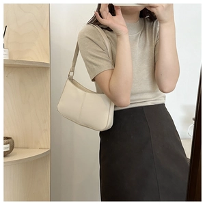 Selfie miroir montrant le sac hobo blanc crème avec des coutures verticales texturées